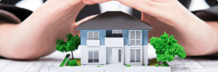Hands hovering over mini house